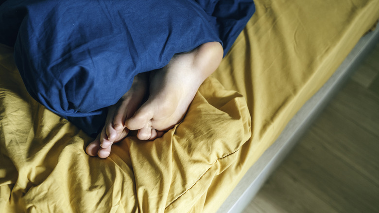 feet in yellow bed sheets