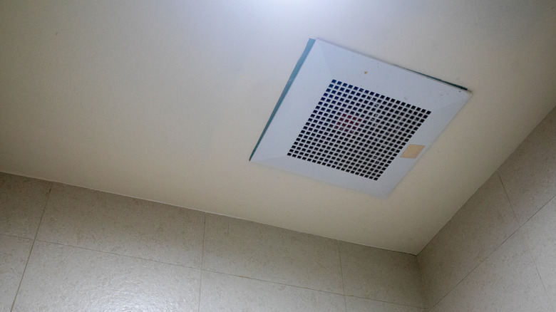 A bathroom exhaust fan is mounted on a cream-colored ceiling