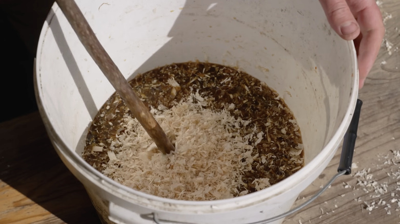 Mixing fish fertilizer in five gallon bucket