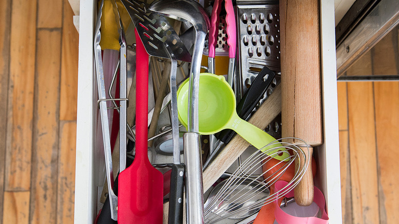Cluttered drawer filled with kitchen items