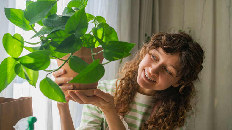smiling person holding pothos