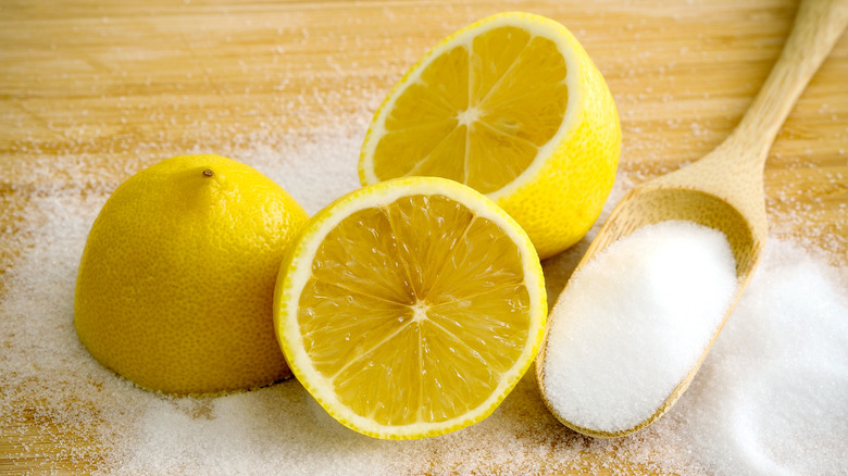 Halved lemons and some salt on a cutting board